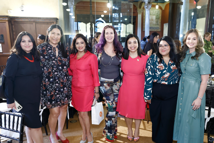 Group of attendees at the 2024 UH Houston Public Library Foundation (HPLF) Luncheon. Seven women stand together, dressed in professional and colorful attire, smiling for the camera in an elegant indoor venue with a warm, well-lit ambiance. The luncheon gathers community leaders and advocates to support and discuss initiatives related to the Houston Public Library Foundation's mission.