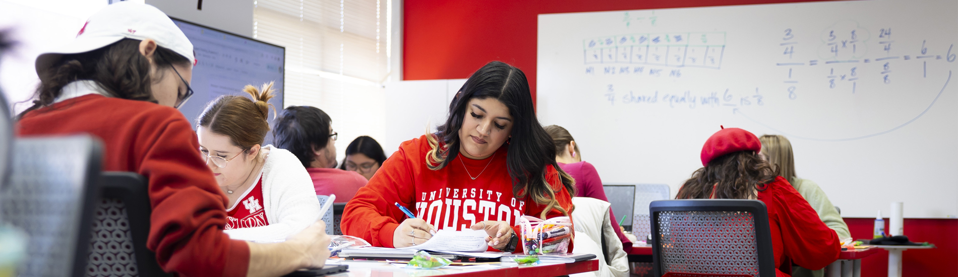 Woman with long brown hair tutoring students