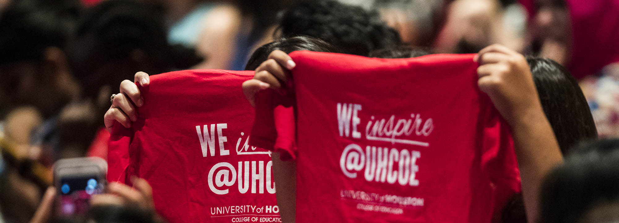 Students holding up t-shirts