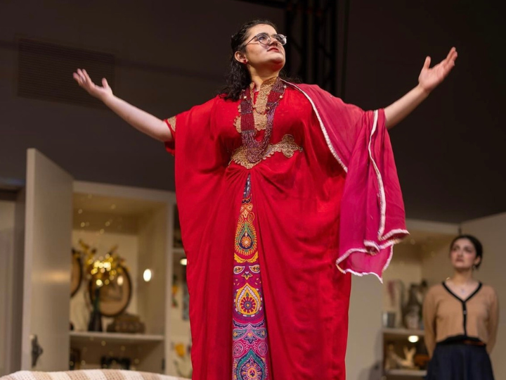 Actress in red dress on stage.