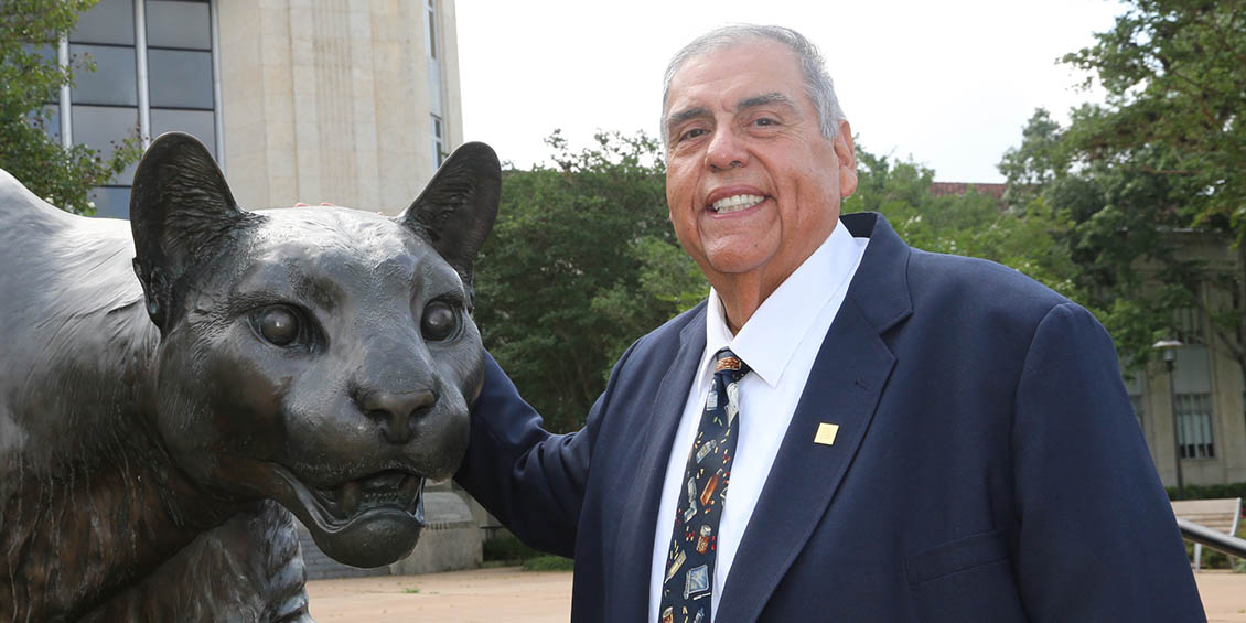 Photo of Celso Cuellar, Jr. with a Shasta statue.