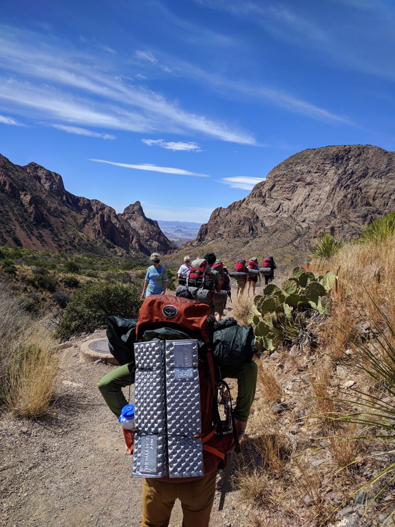 students backpacking on a trail