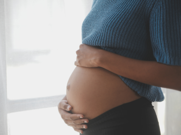 close up on pregnant mother holding belly