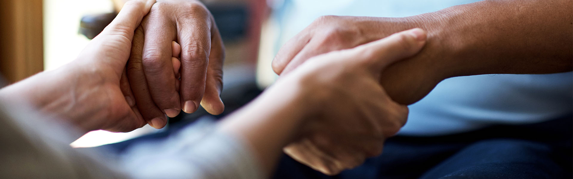 caregiver holding patient's hands