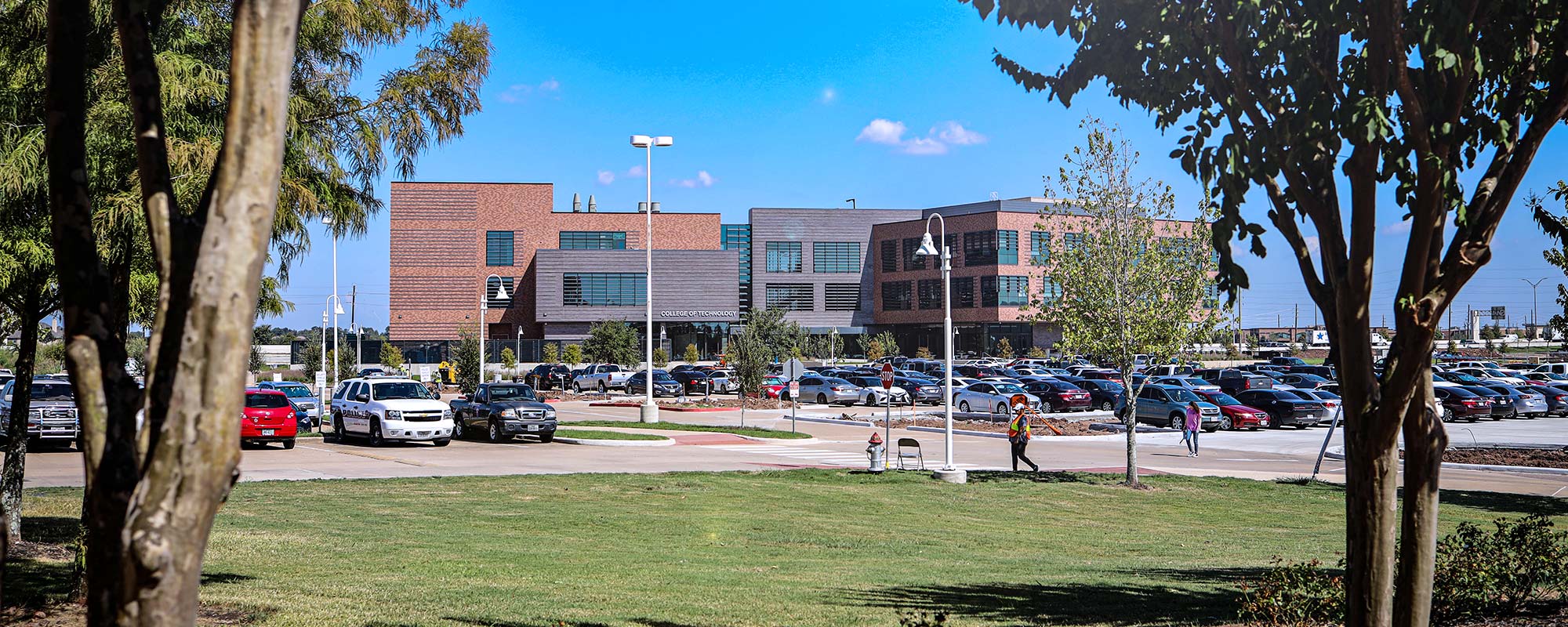 Landscape photo of a three story building framed by two trees