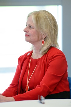 A woman sitting at a table facing left