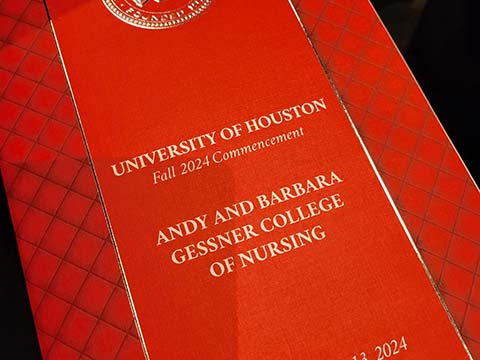 Red front cover of an event program. The words "University of Houston Fall 2024 Commencement. Andy and Barbara Gessner College of Nursing" appear on the cover in gold letters.