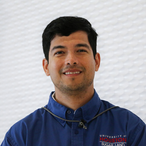 Portrait of a Hispanic man smiling wearing a blue button-up shirt